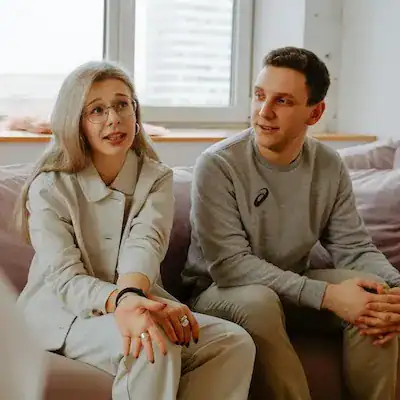 couple sitting on therapist's sofa talking