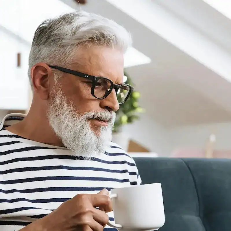 man with striped tshirt holding mug