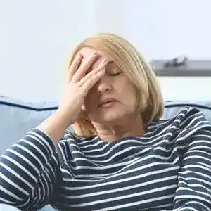 woman with hand over face looking in pain
